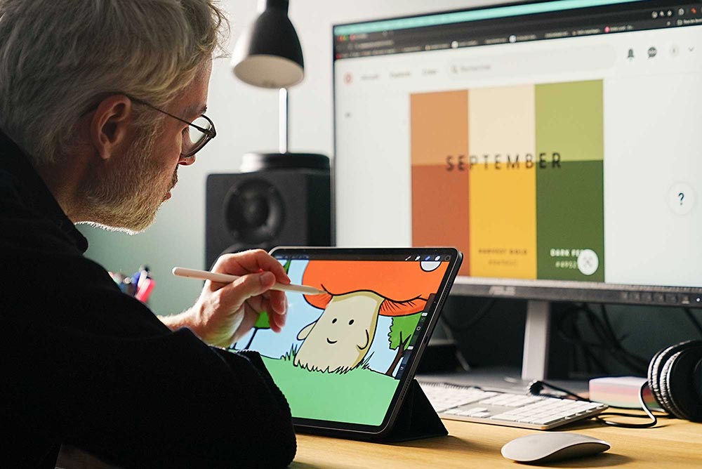 Un homme dessine sur une tablette tactile