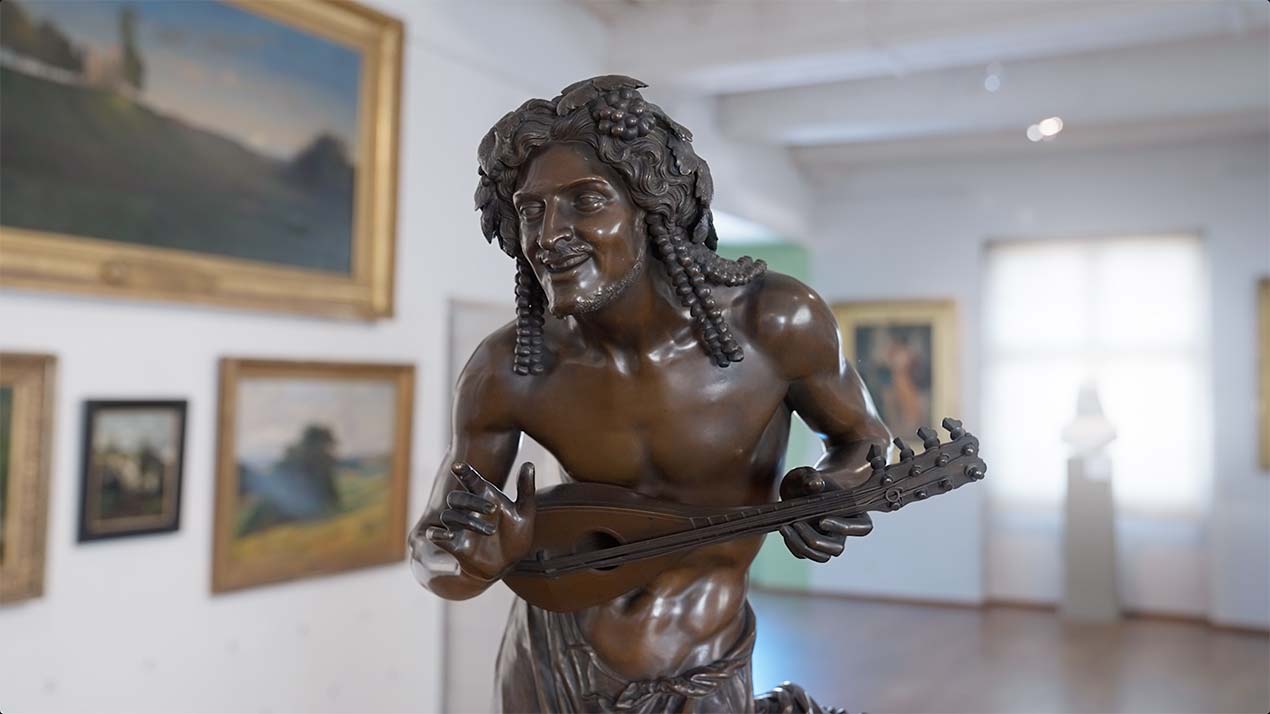 Sculpture en bronze d'un homme qui joue de la mandoline